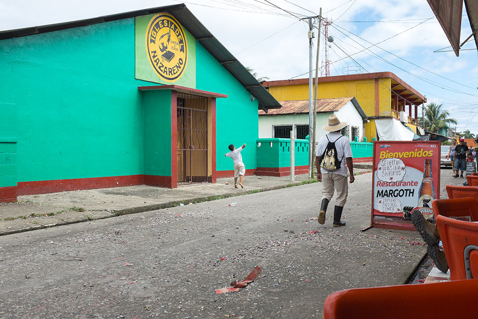 Kid throwing firecrackers in the street, Livingstone, Guatemala